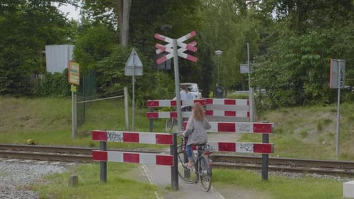 Dois ciclistas passando por uma passagem de nível sem vigilância na Holanda