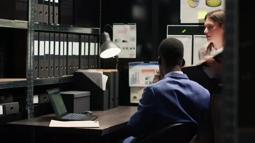 Colleagues Working Late in Dark Office at Computer