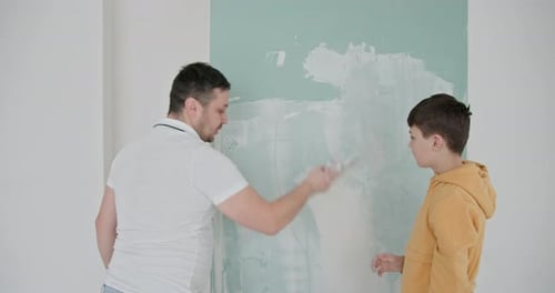 Father and Son Patching Wall Together