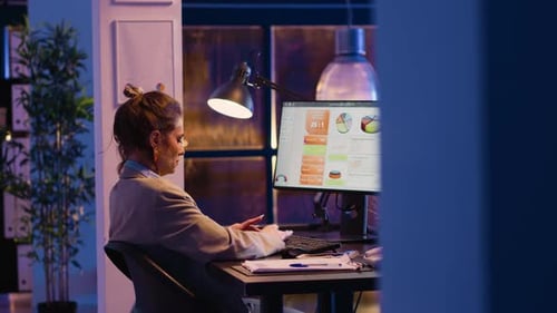 Woman Works Late at Computer in Dark Office