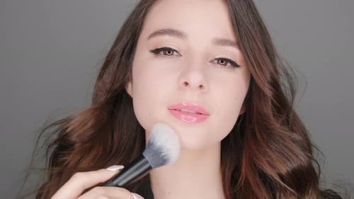 Woman Applies Makeup with Brush Close Up