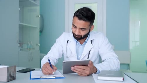Terapeuta médico de medicina general serio masculino indio en una clínica moderna en White