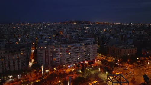 Forwards Fly Over Square and Buildings in Urban Neighbourhood Revealing Illuminated Street Night