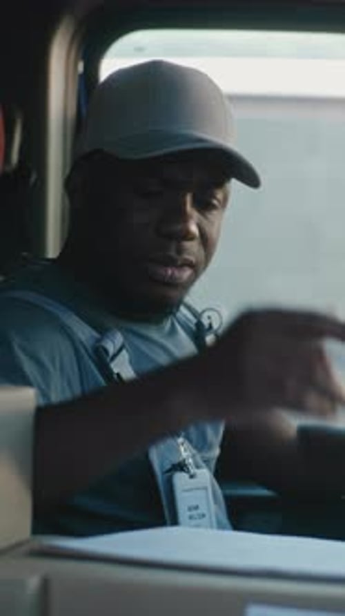 Chauffeur de camion de livraison assis dans une voiture utilisant une tablette numérique remplissant des papiers