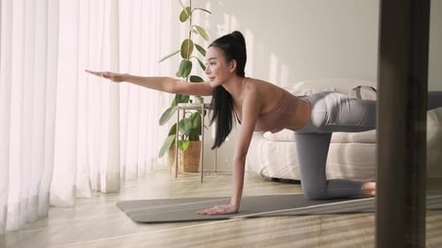 Woman Balancing in Yoga Pose at Home