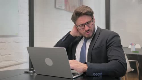 Man Working on Laptop at Desk Has Neck Pain