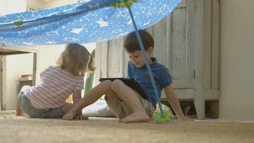 Boy and Girl Play in Living Room Fort