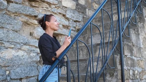 Mujer toma una foto junto a Ancient Wall en un día