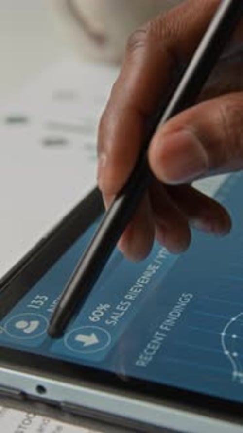 Empleado analiza los ingresos por ventas en una tableta digital en la oficina