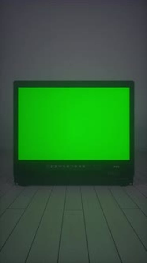 Old TV Displaying Green Noise Effect on Wooden Floor Background