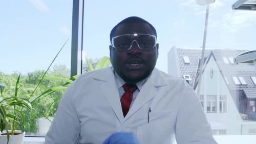 Man in Lab Coat Putting on Gloves