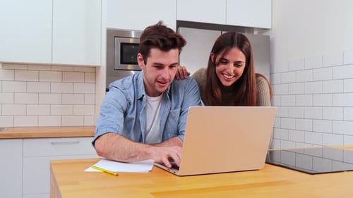Happy Couple Using Laptop in Modern Kitchen