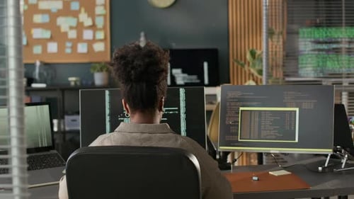 Black Female Software Developer Working Alone in Empty Programmers Office
