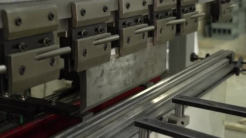 Die Hände des Mitarbeiters biegen nicht die großen Teile des Metalls auf der Biegemaschine. Nahaufnahme