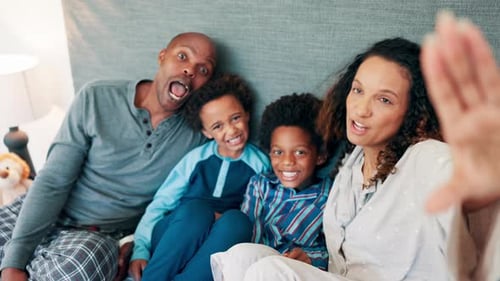 Playful Family Posing in Pajamas on Bed