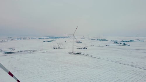 Wind Power Turbines Generating Renewable Clean Energy in Cold Frozen Snowy Winter