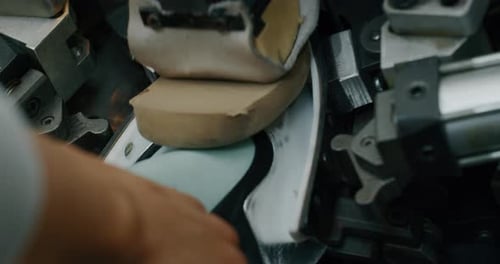 Macro of a shoemaker using a professional machine to bend the shoes and fix them according to the