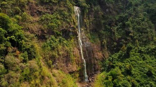 Tall rainforest waterfall Diamante cascading down a steep cliff in Costa Rica