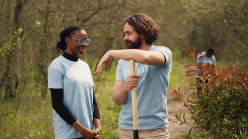 Diverse Volunteers Smiling and Helping in a Leafy Setting