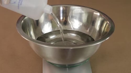 Pour alcohol into a bowl on a weighing machine. Chemical instruments.
