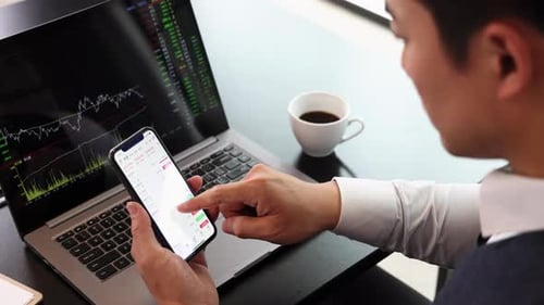 Businessman analyzing stock market candlestick charts trends on computer screen and smartphone, util