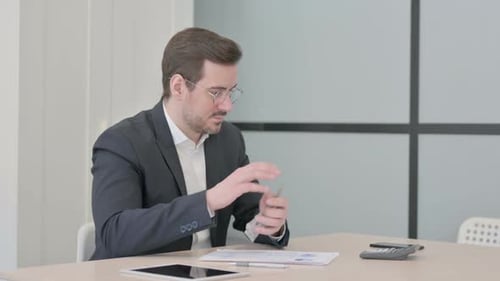 Man Counts Money and Calculates Finances in Office