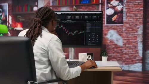 Woman Analyzing Financial Data at Computer in Office
