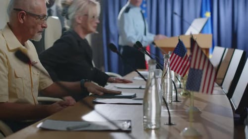 Press Conference with Officials Sitting at Table
