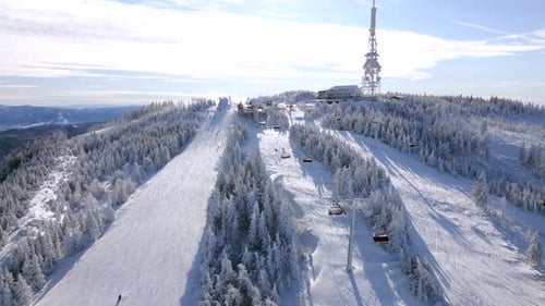 Aerial View of Snowy Ski Resort with Cable Cars and Winter Forest
