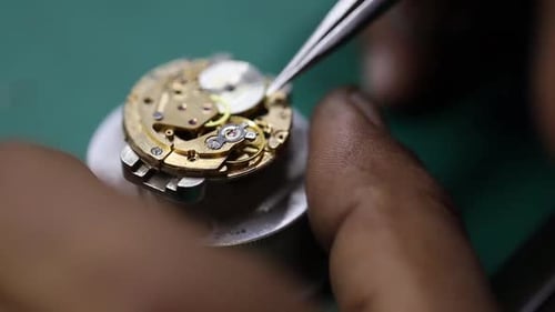 vidéo rapprochée d'un artisan réparant délicatement une montre vintage