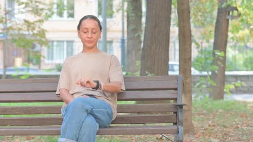 Woman Checks Smart Watch in City Park