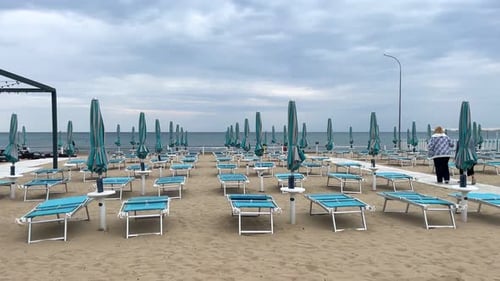 Sandy Beach with Parasols and Empty Deck Chairs Awaiting Tourists