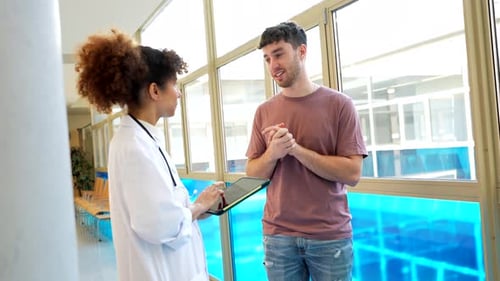 Doctor Interviewing Patient in Hospital Hallway