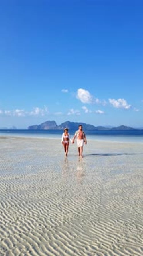 A Couple Strolling Along the Beach Hand in Hand Under a Cloudy Sky Koh Kradan Thailand