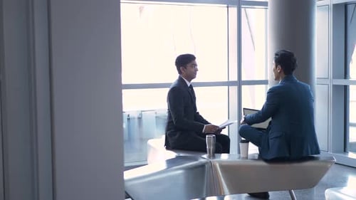 Mature businessmen from India and asia discussing plans in an office lobby