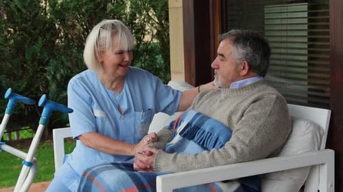 Caregiver Talking with Senior Patient in Chair