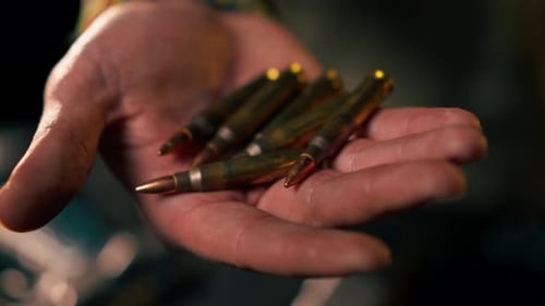 Hand Holding Several Bullets Close Up