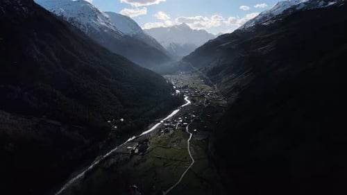 Tal mit Fluss, der inmitten von Bergen unter bewölktem Himmel fließt