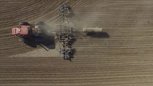 Big red combine working on the field cultivating and applying nitrogen ASP