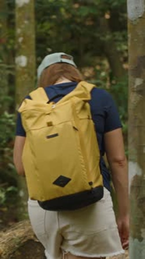 Vertical video. Woman in Cap and Yellow Backpack Hiking Up Rocky Forest Trail on Samui Island Surrou