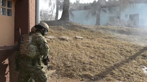 Soldiers in military exercise with weapons running outdoors in camouflage uniforms