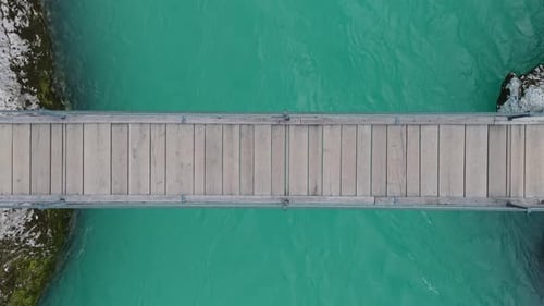 Hängebrücke aus Holz über den türkisfarbenen Fluss Soca in Slowenien