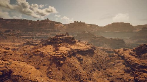 Desert Landscape with Rocky Formations and Distant Cliffs Under a Clear Sky