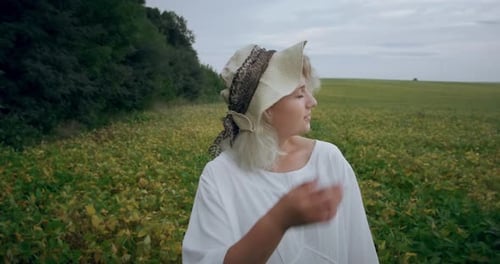 Jeune fille posant dans un champ avec un chapeau sur la tête