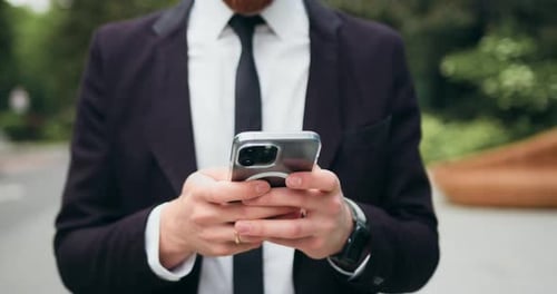Close up. Serious business man using mobile phone outside. Chatting, online and commute with male