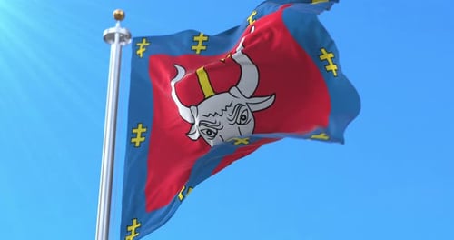 Waving Flag with Bull Head and Cross Symbol Against Blue Sky