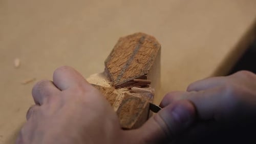 Craftsperson Carefully Carving Small Piece of Wood