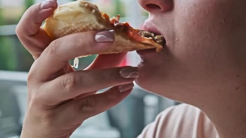 Woman Eating Pizza Slice in Close Up