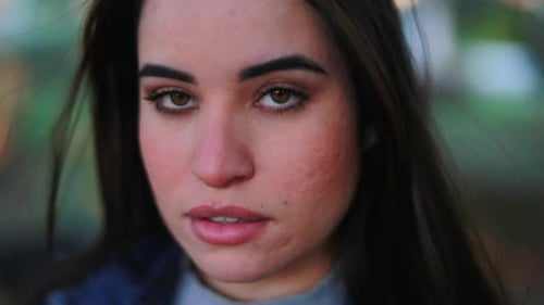 Young Woman Looking Seriously at Camera Outdoors