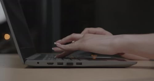 Woman Typing on Laptop at Desk Close Up